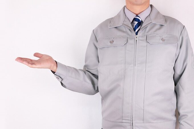 片手を挙げる作業員