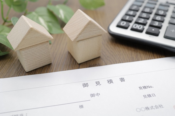 見積書と電卓と2つの家の模型